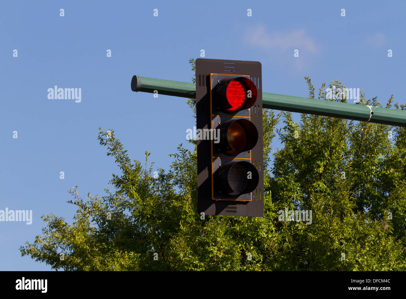 Traffic signal, stop light, red light, or traffic light.  Blue sky and green trees in the background Stock Photo