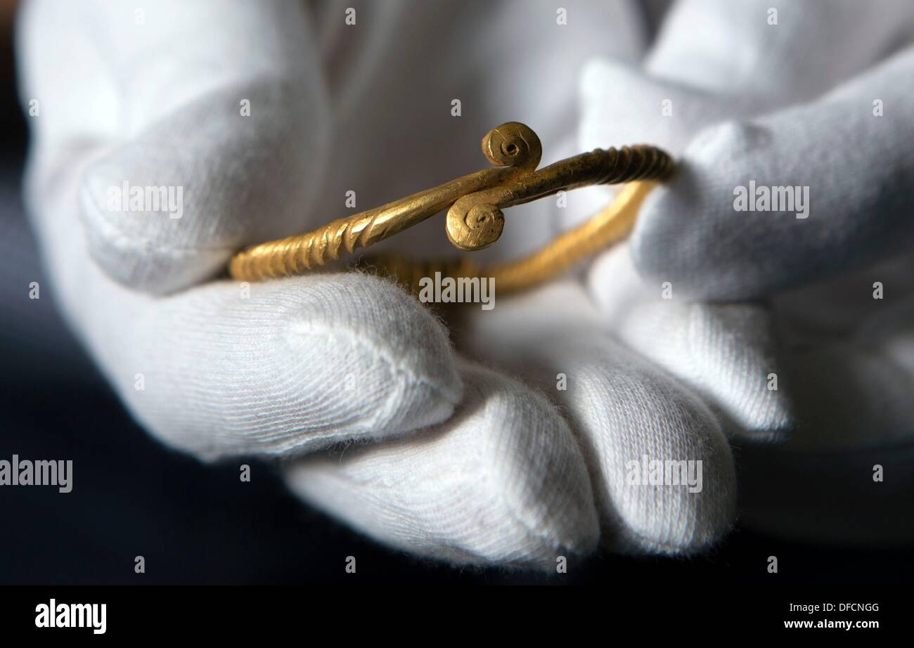 A more than 3,000 year old golden ring lies on the glove of an
