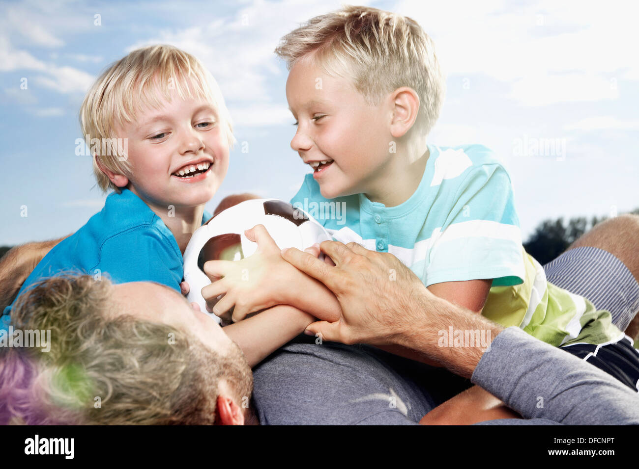 Germany, Cologne, Father and sons playing soccer Stock Photo Alamy