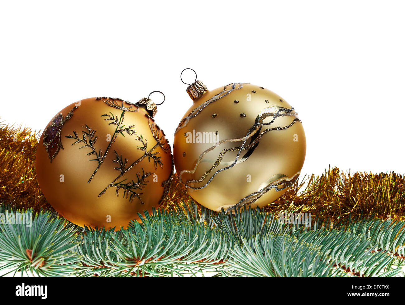 New-year decorations. Green Christmas balls, fir-tree and yellow tinsel Stock Photo