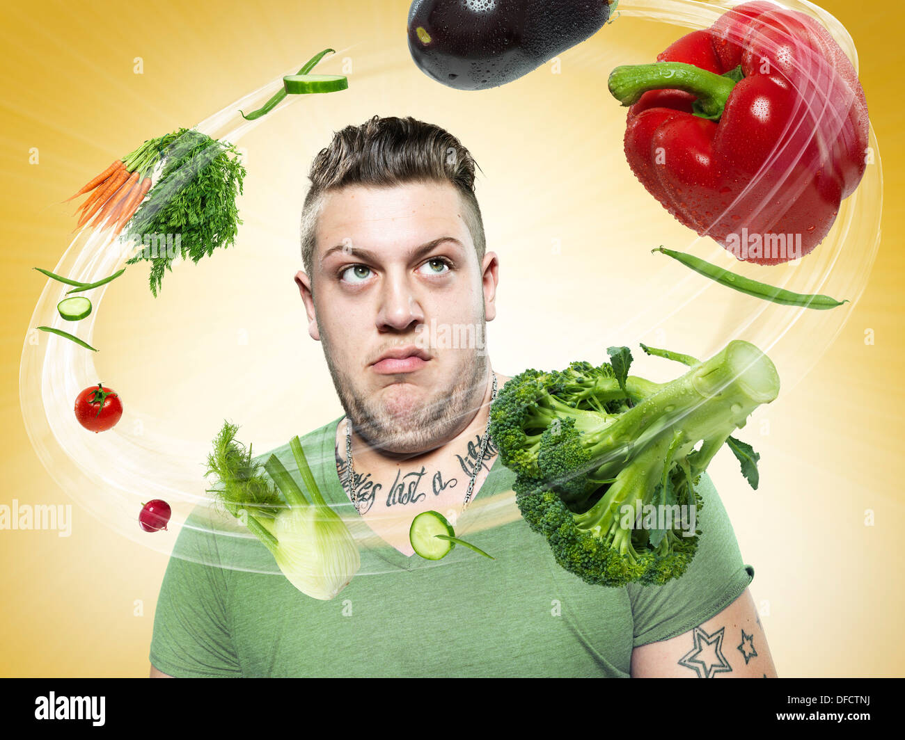 Young man looking at flying vegetables, Composite Stock Photo