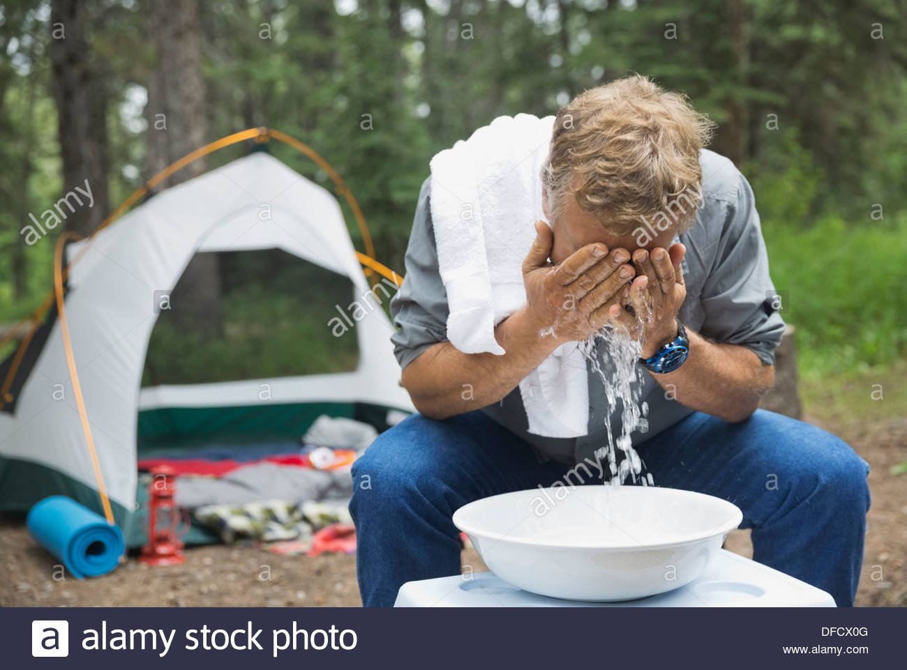 Mature man washing face at campsite Stock Photo Alamy