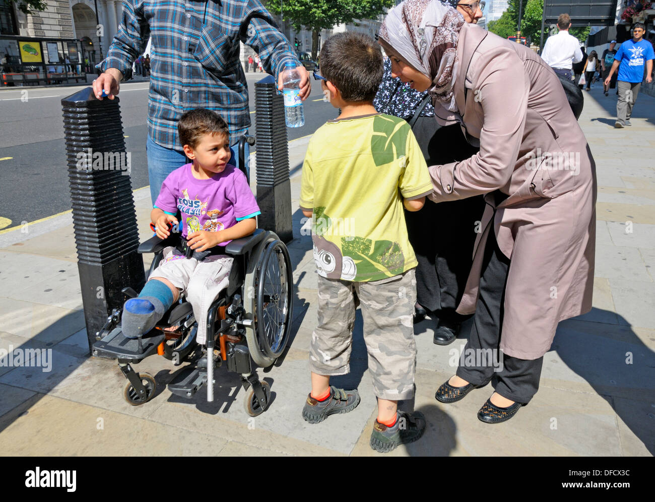 London, England, UK. Middle eastern family with a young boy in a wheelchair. Stock Photo