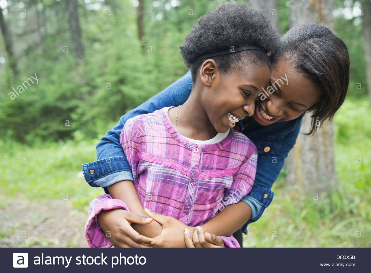 Cheerful sisters hugging outdoors Stock Photo