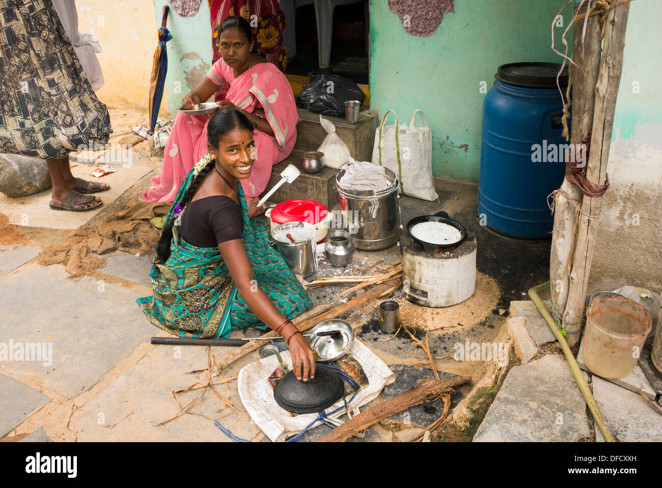 Indian woman cooking dosa for people outside a rural village house. Andhra Pradesh, India Stock Photo