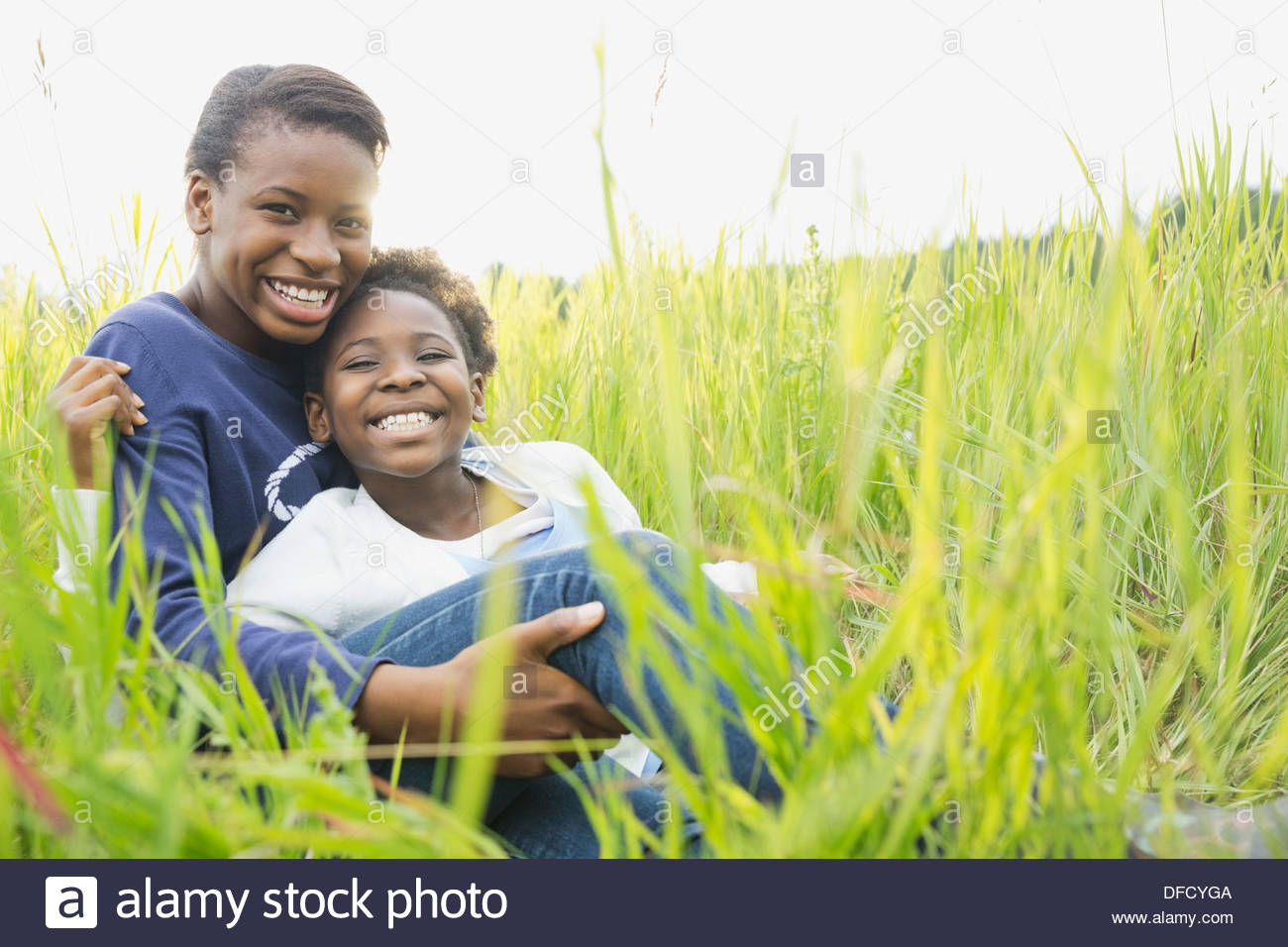 Portrait of loving sisters embracing outdoors Stock Photo