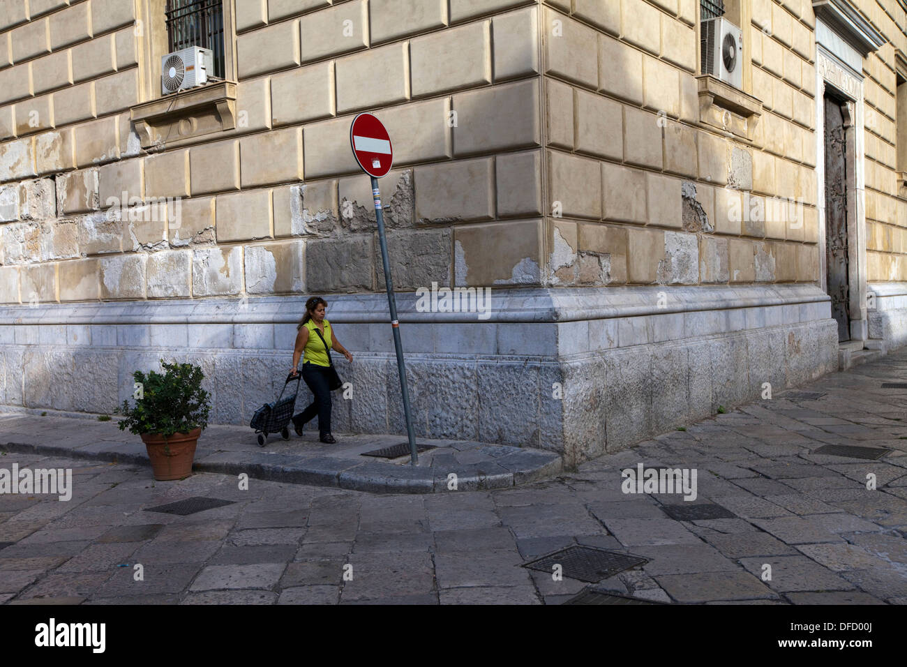 A woman wheels her shopping trolley through the Piazza Bellini, Palermo, Italy Stock Photo