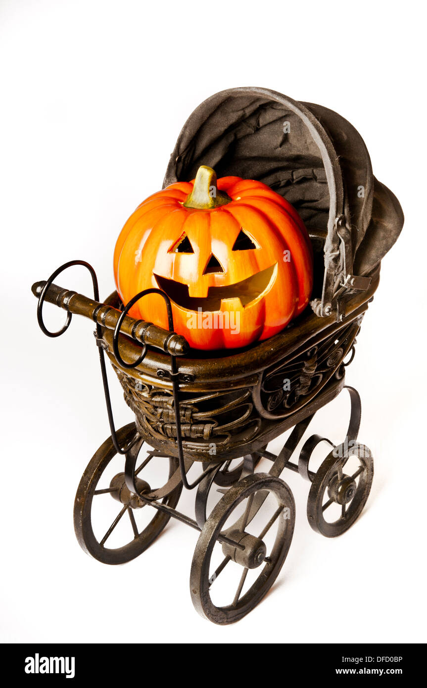 Halloween carved pumpkin in a Victorian stroller Stock Photo