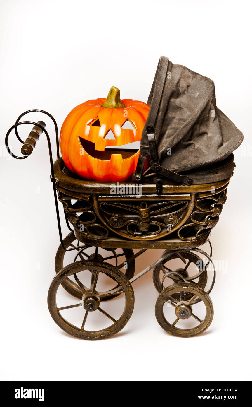 Halloween carved pumpkin in a Victorian stroller Stock Photo