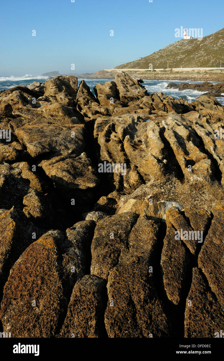 Coastal rockery in As Marinas and Cape Silleiro lighthouse. Galicia, Spain Stock Photo