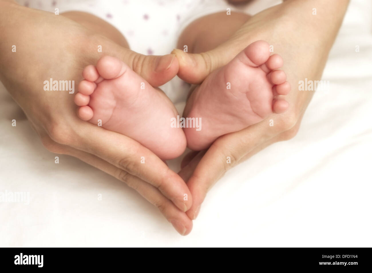 Newborn baby feet in the mother hands Stock Photo