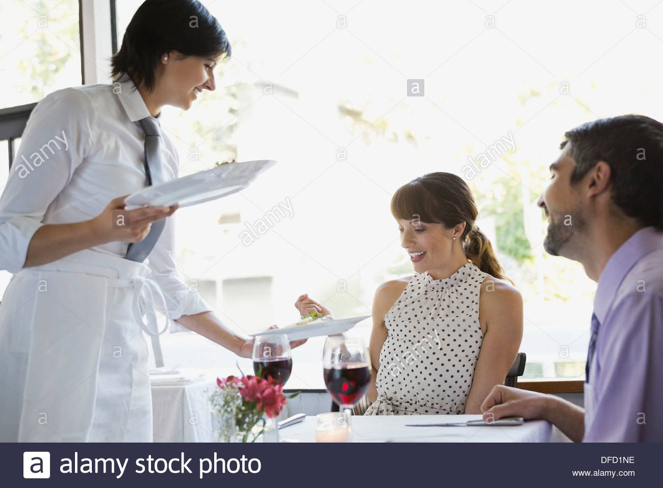 Waitress Serving Food To Couple In Restaurant Stock Photo Alamy