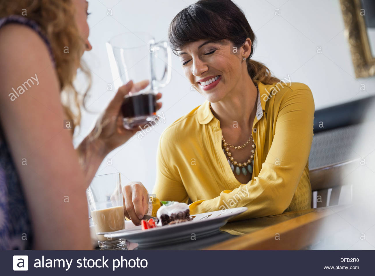 Female friends laughing while dining out Stock Photo