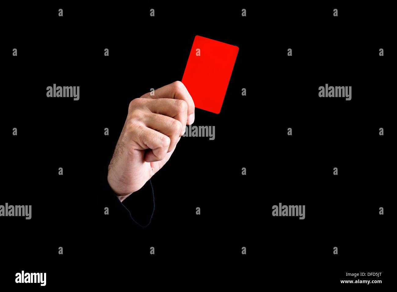 Soccer referee giving red card on black background. Stock Photo