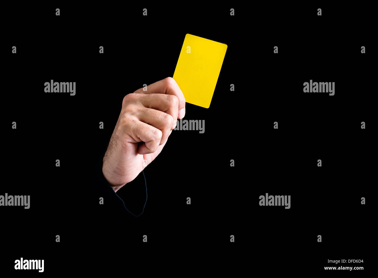 Soccer referee giving yellow card on black background. Stock Photo