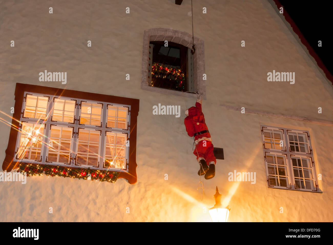 Santa claus climbing on house wall Stock Photo