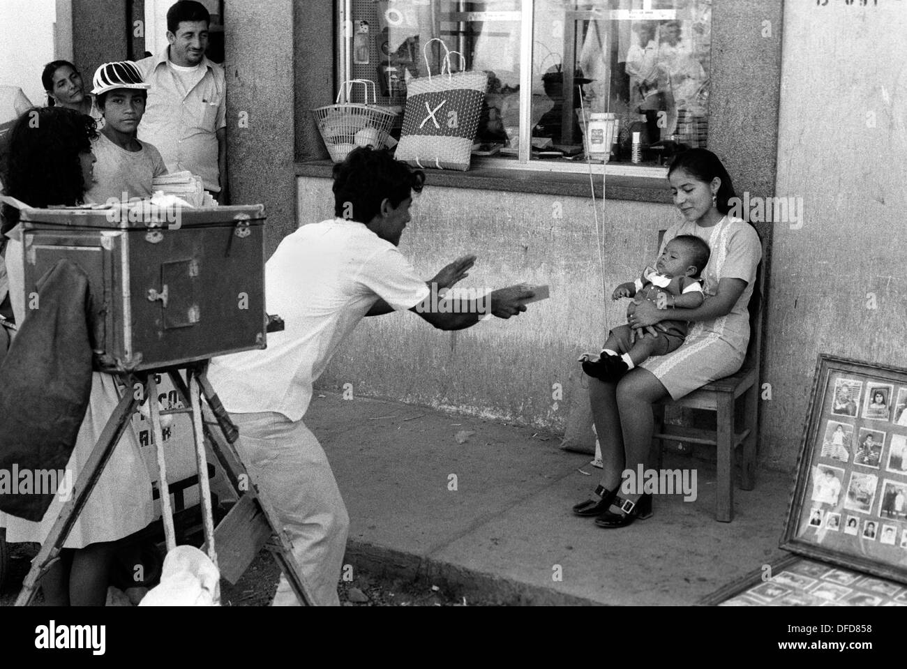 Managua Nicaragua 1973. Street photographer using an old fashioned wooden plate camera to make take a photograph of a mother and new baby son. 1970s Central America, HOMER SYKES Stock Photo