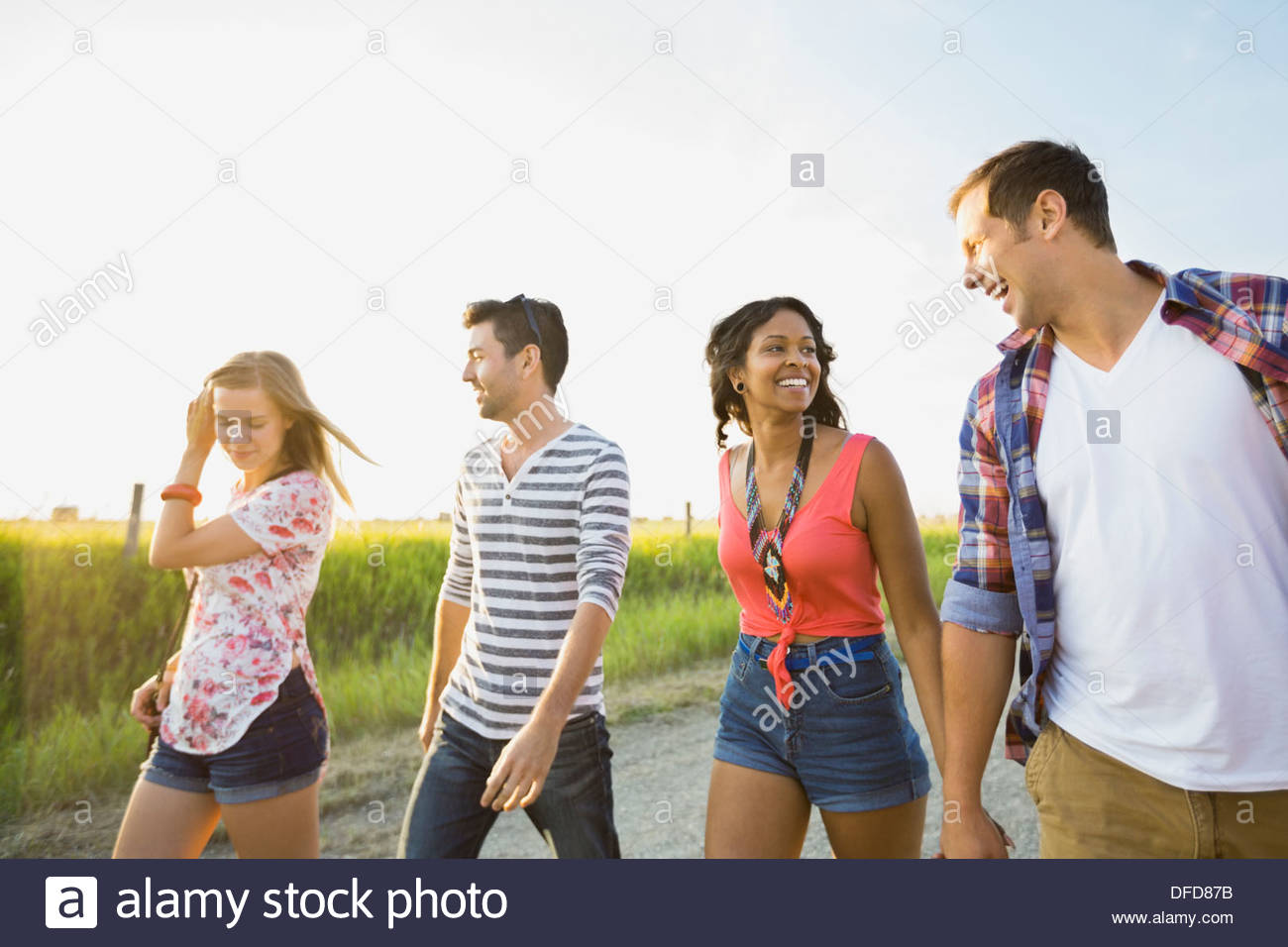 Young friends walking on country road Stock Photo