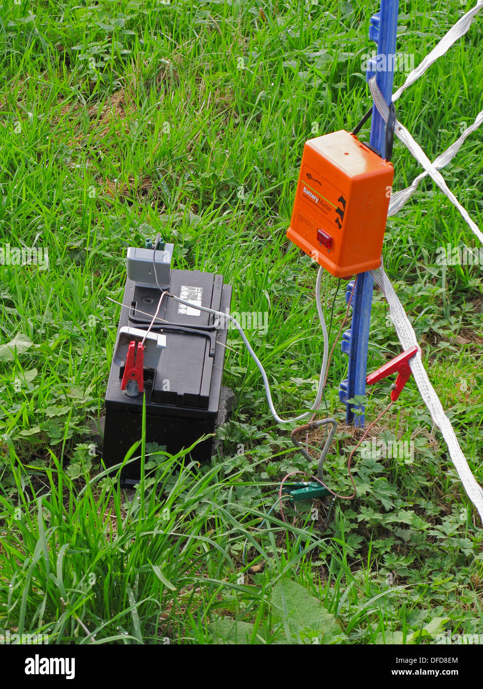 Electric Fence with Electrical Transformer and Battery Power Pack in a Field Stock Photo