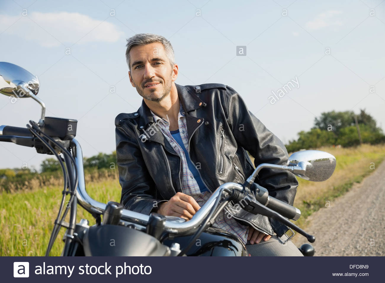 Portrait of confident biker sitting on motorcycle Stock Photo