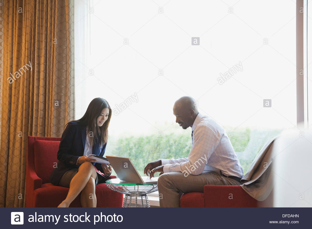 Business people working on laptop in hotel lobby Stock Photo