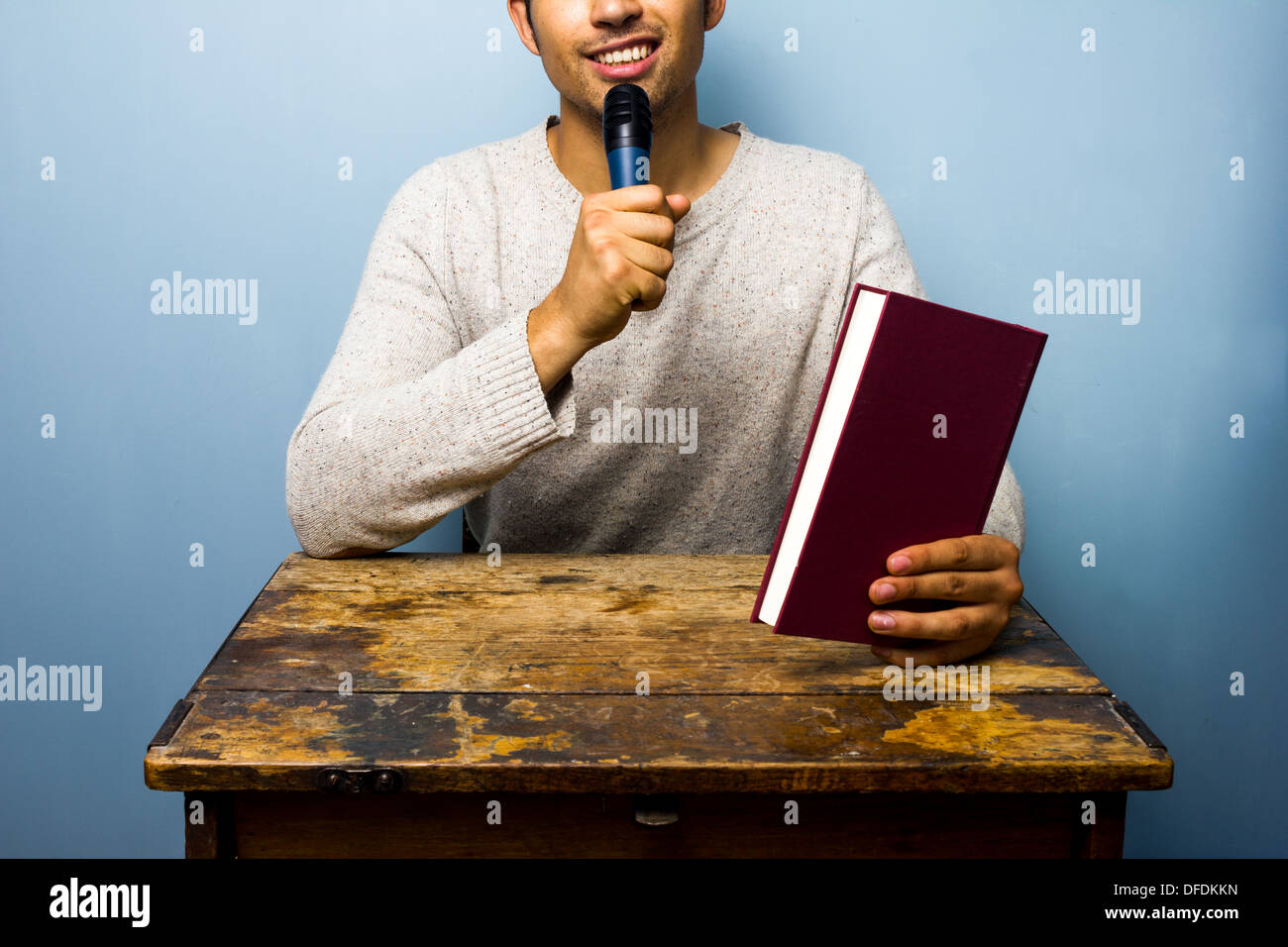 Young author is speaking into microphone at book signing Stock Photo