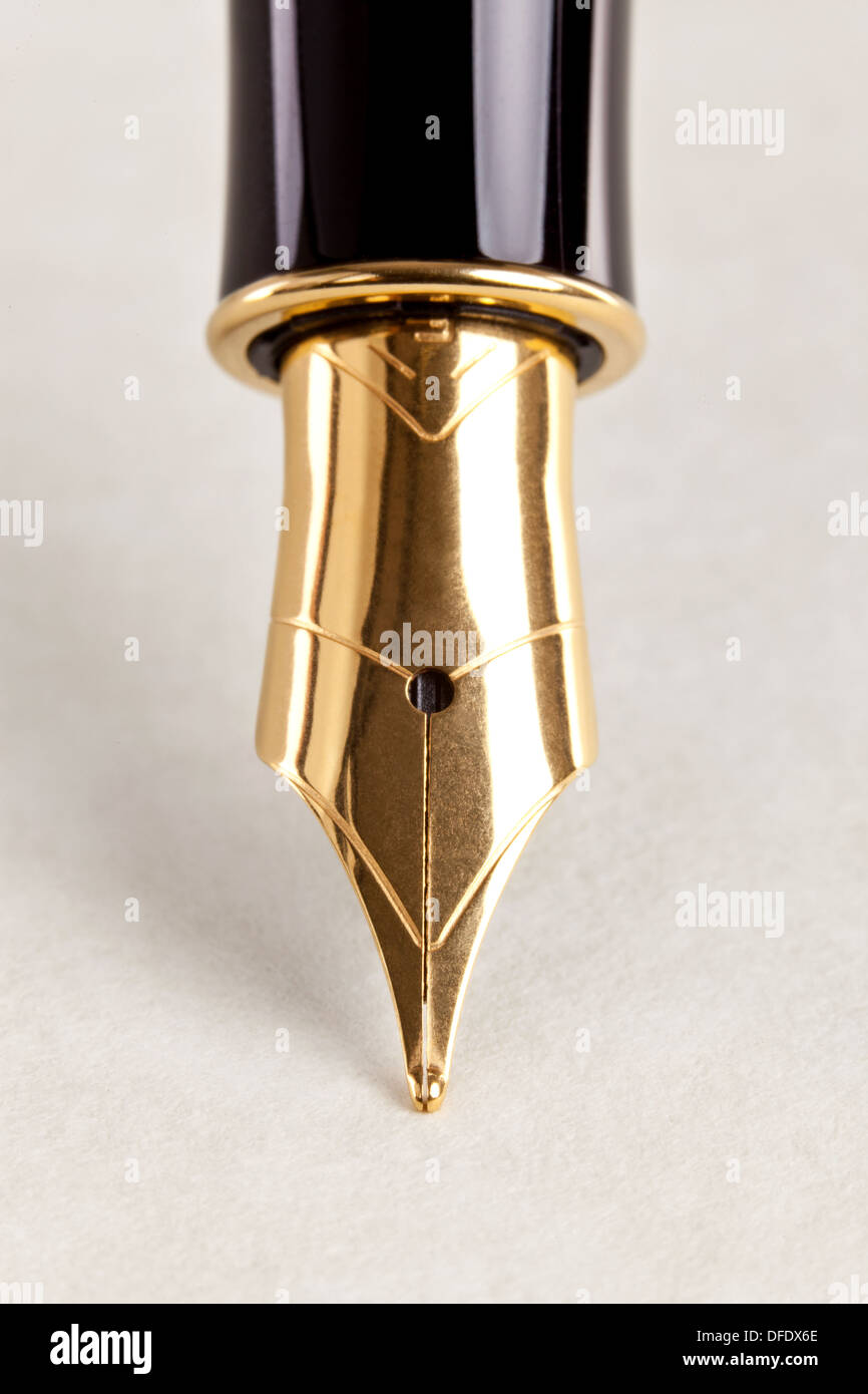 Close-up photo of a gold nib fountain pen on expensive paper. Stock Photo