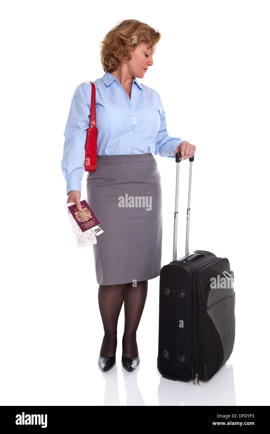 A businesswoman with suitcase, passport and tickets checking the time on her watch. Stock Photo