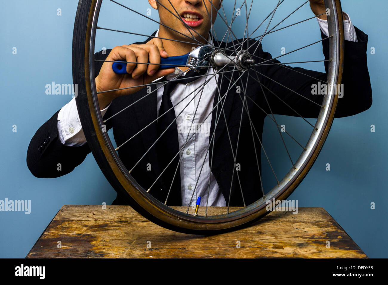 Young businessman is trying to fix a bicycle tire Stock Photo Alamy