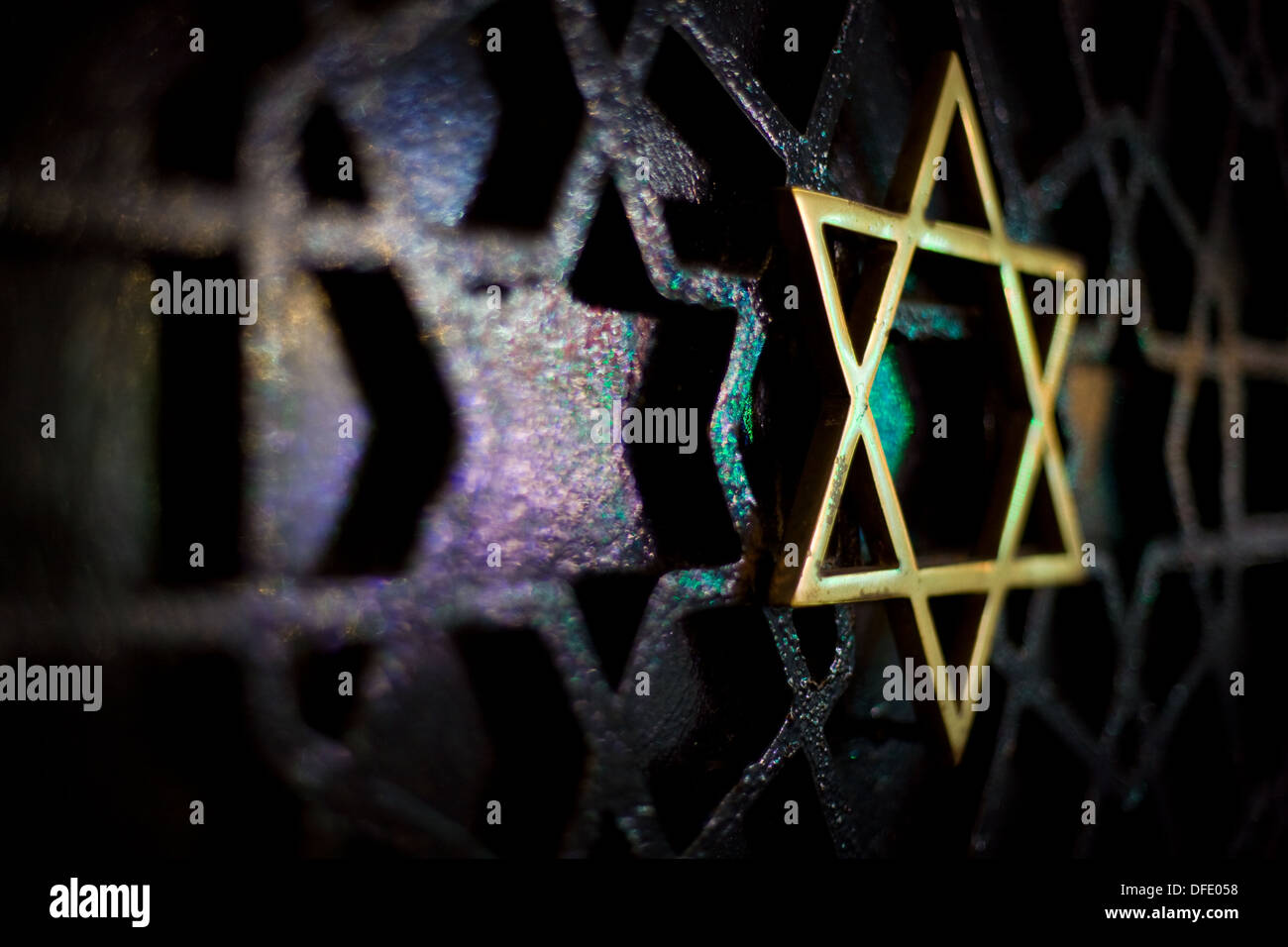 Gold coloured star design on a metal gate in Istanbul, Turkey. Lit by the colourful lights from surrounding shops and stalls Stock Photo