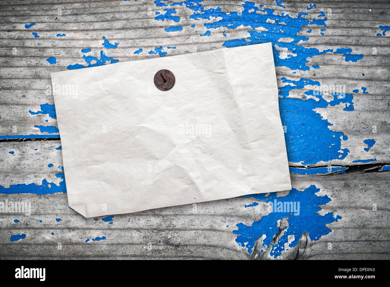 Empty paper ad hanging on vintage wooden wall with blue paint Stock Photo