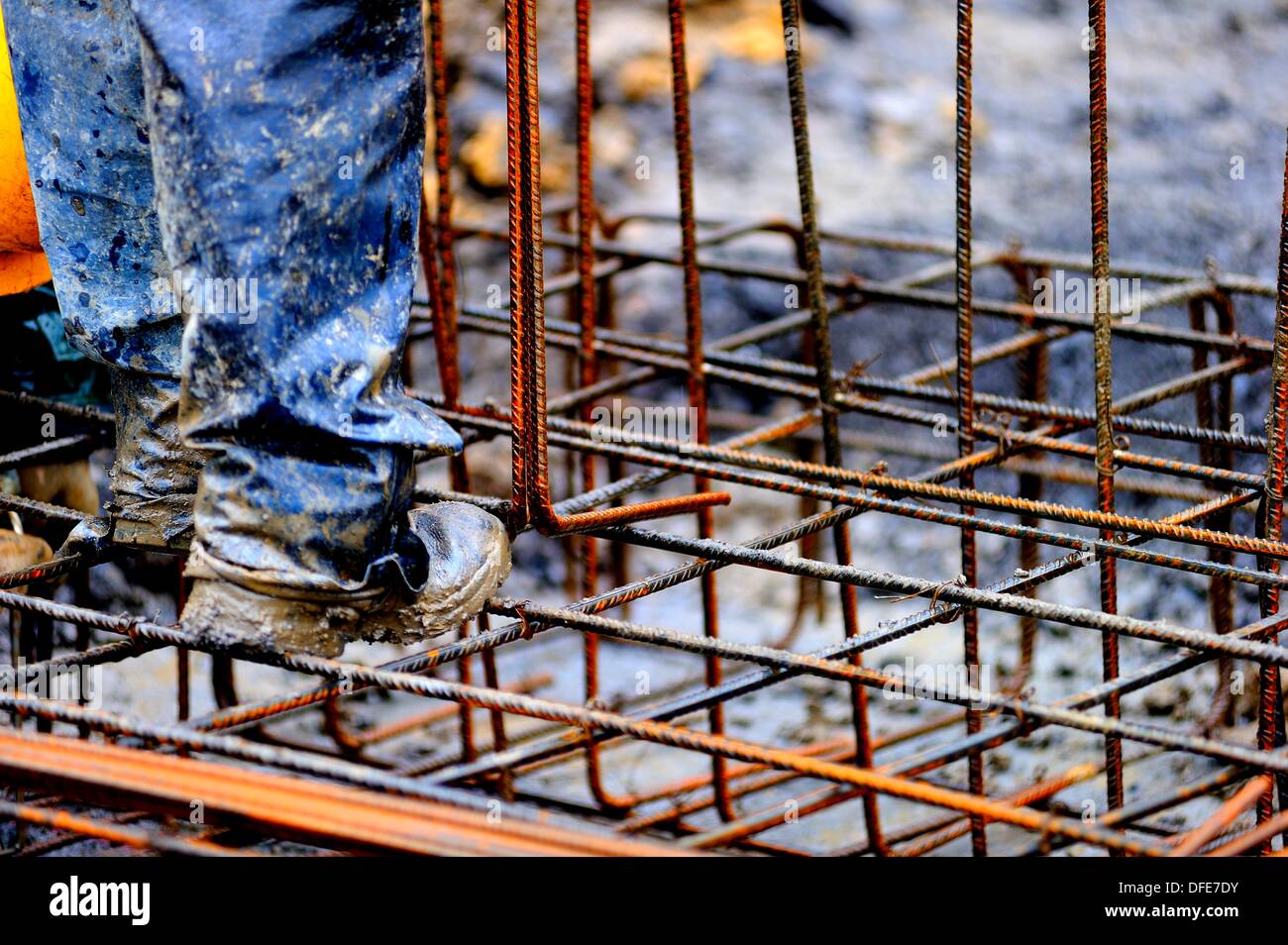 High-contrast image of a construction worker preparing a structure for pouring concrete rebar Stock Photo