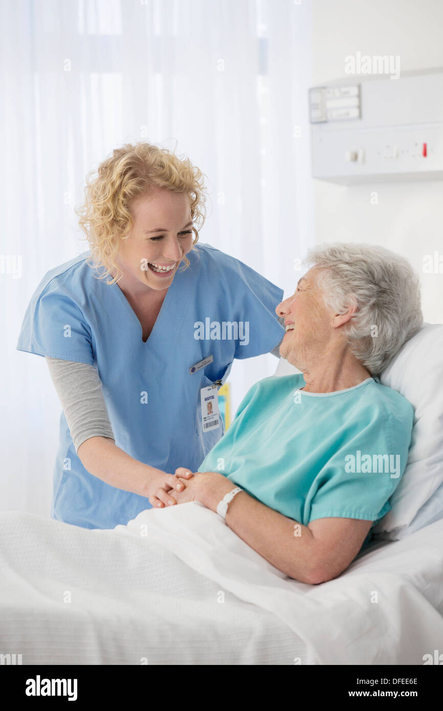 Nurse and senior patient talking in hospital room Stock Photo