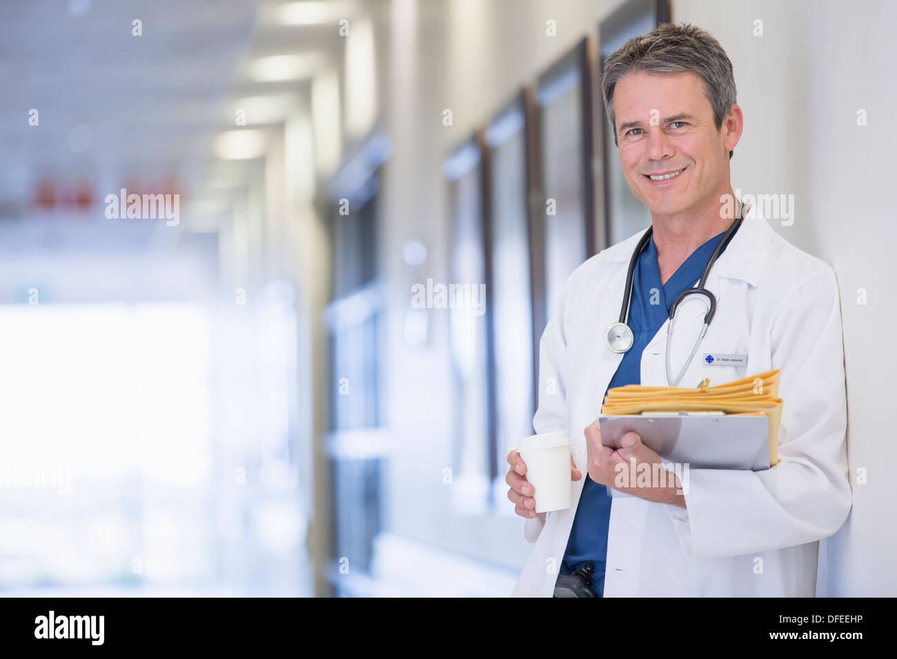 Portrait of smiling doctor in hospital corridor Stock Photo