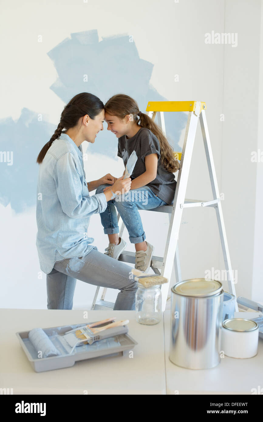 Mother and daughter painting wall blue Stock Photo