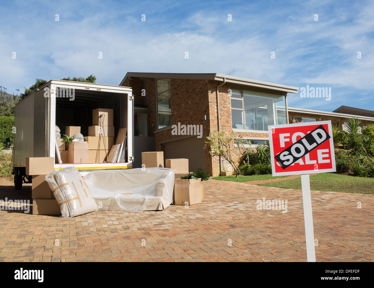 Sold sign and moving van outside house Stock Photo