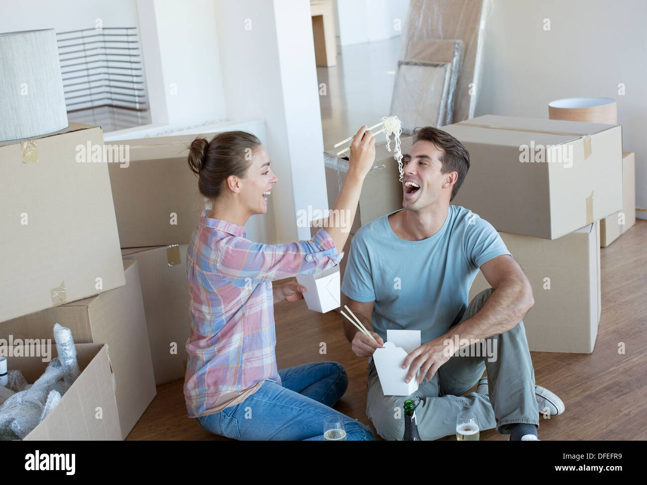 Couple eating Chinese take out food in new house Stock Photo