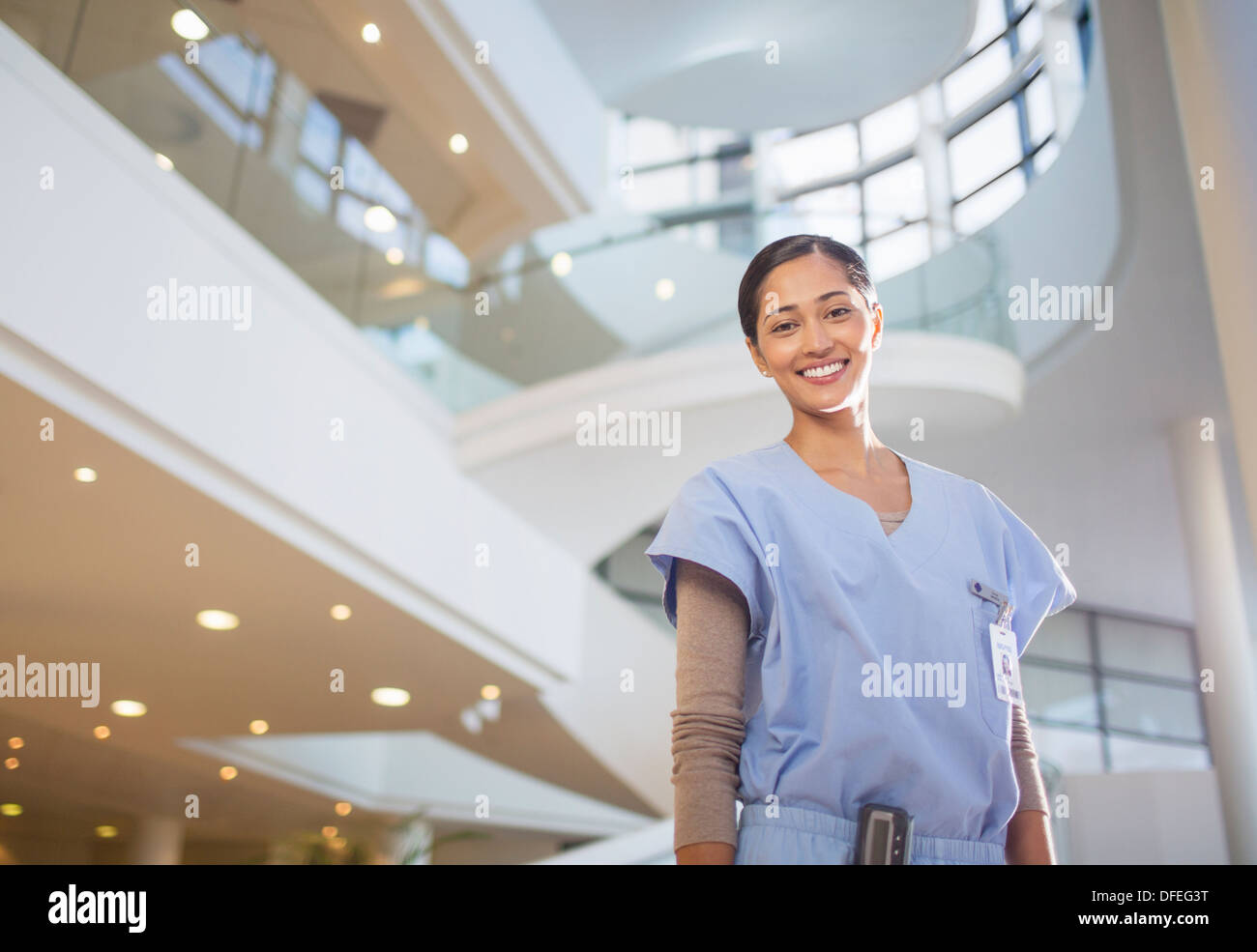 Portrait of smiling nurse in hospital atrium Stock Photo