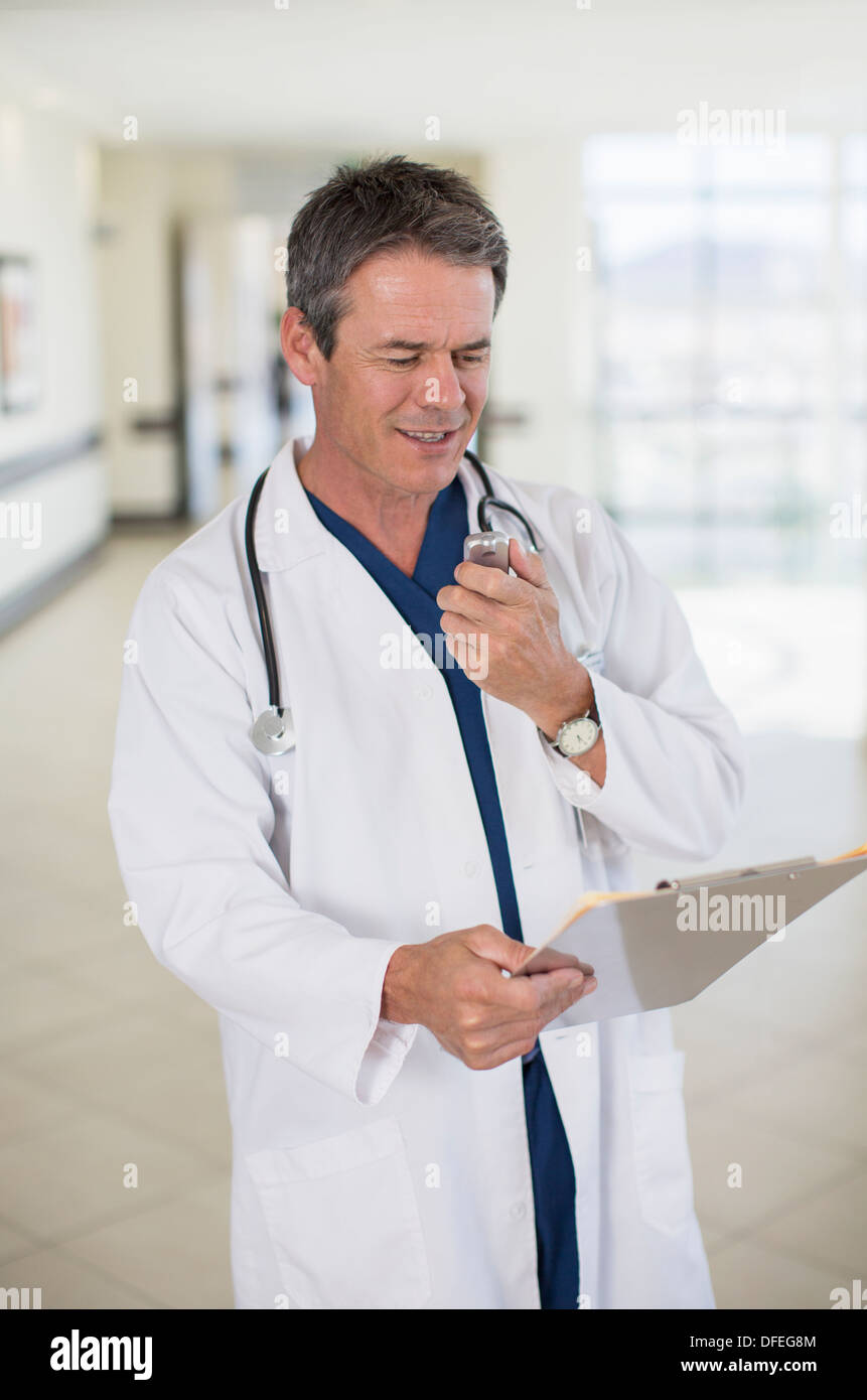 Doctor talking into dictaphone Stock Photo