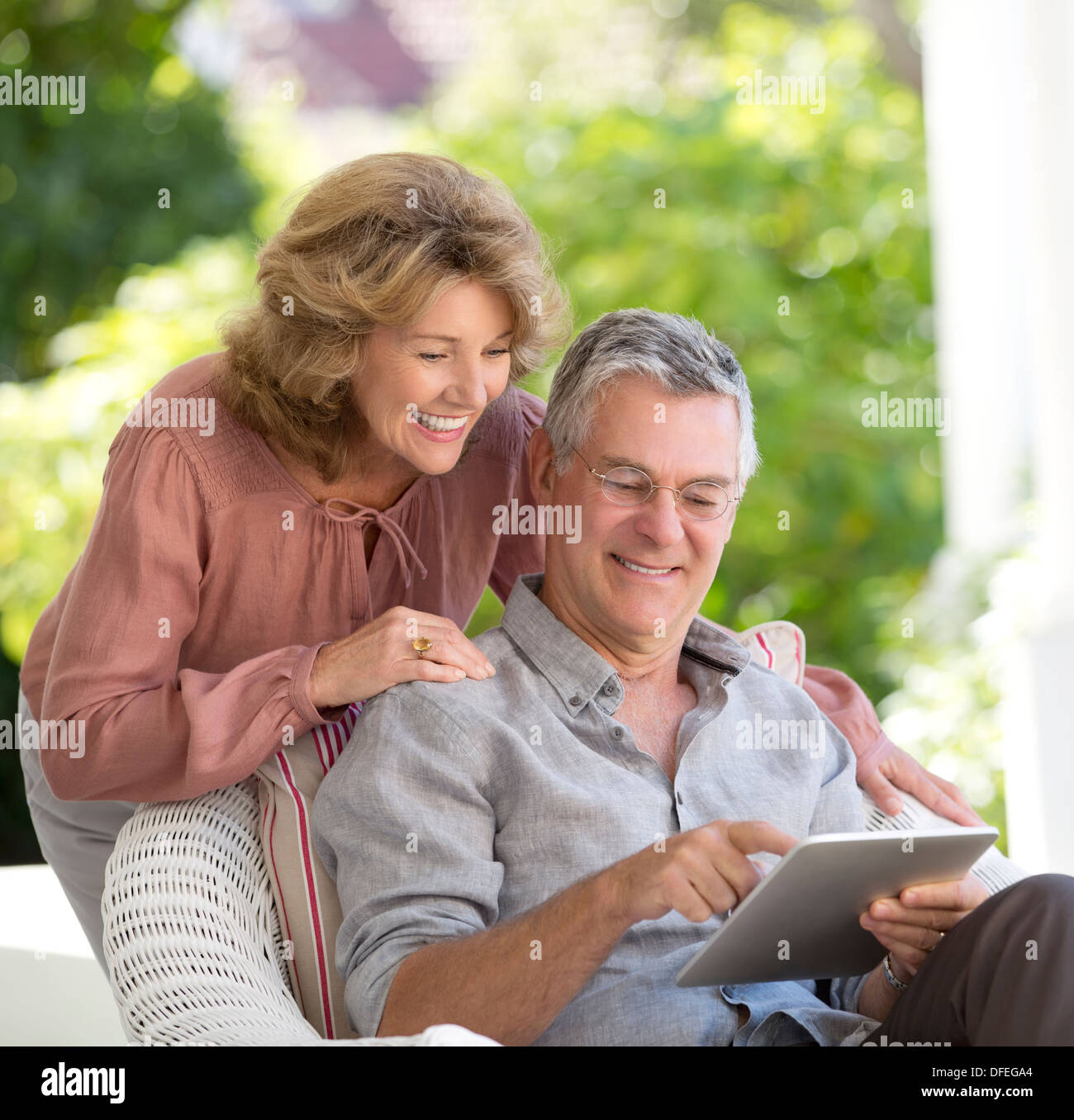 Senior couple using digital tablet on patio Stock Photo