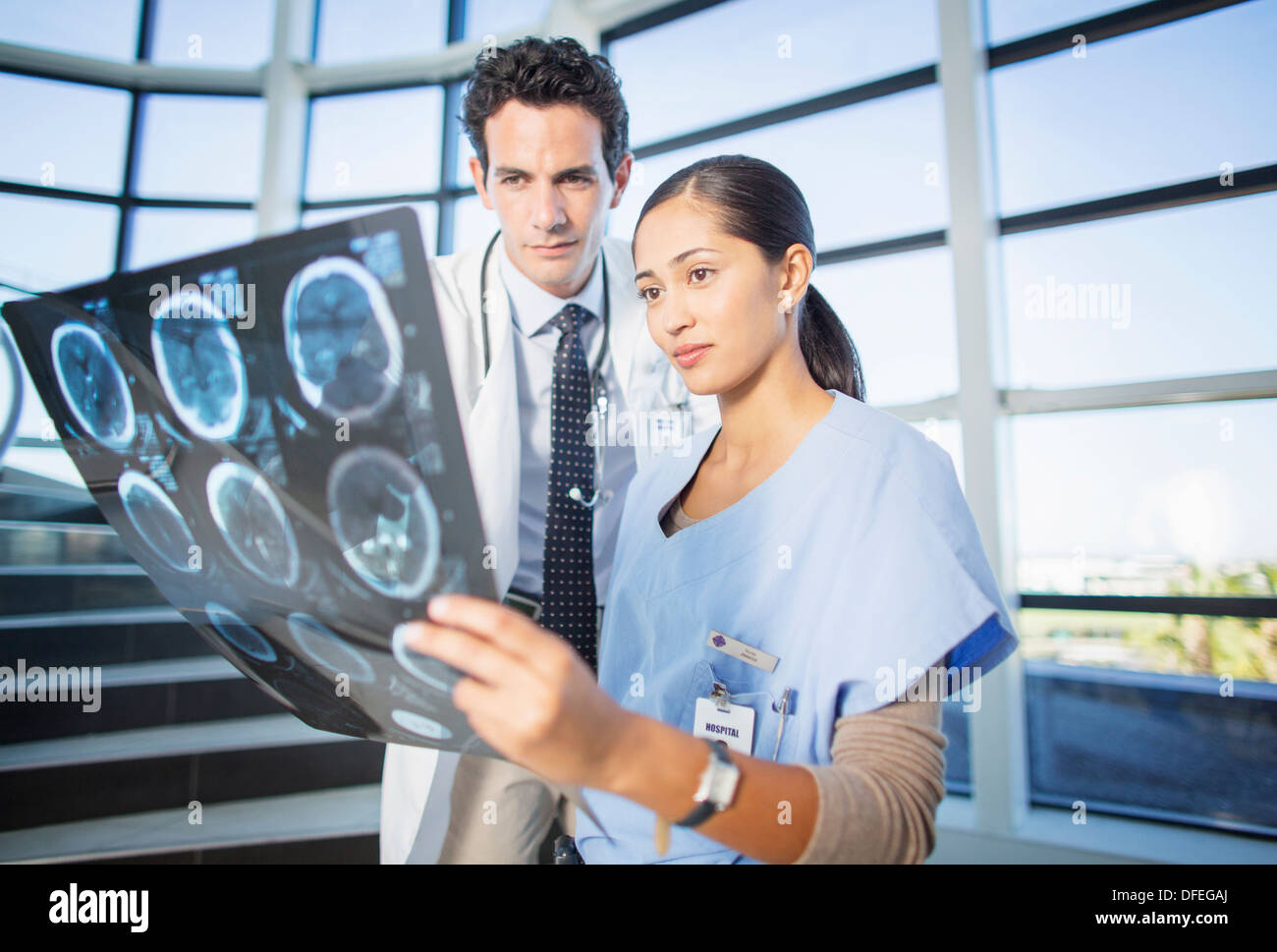 Doctor and nurse viewing head x-rays on hospital staircase Stock Photo