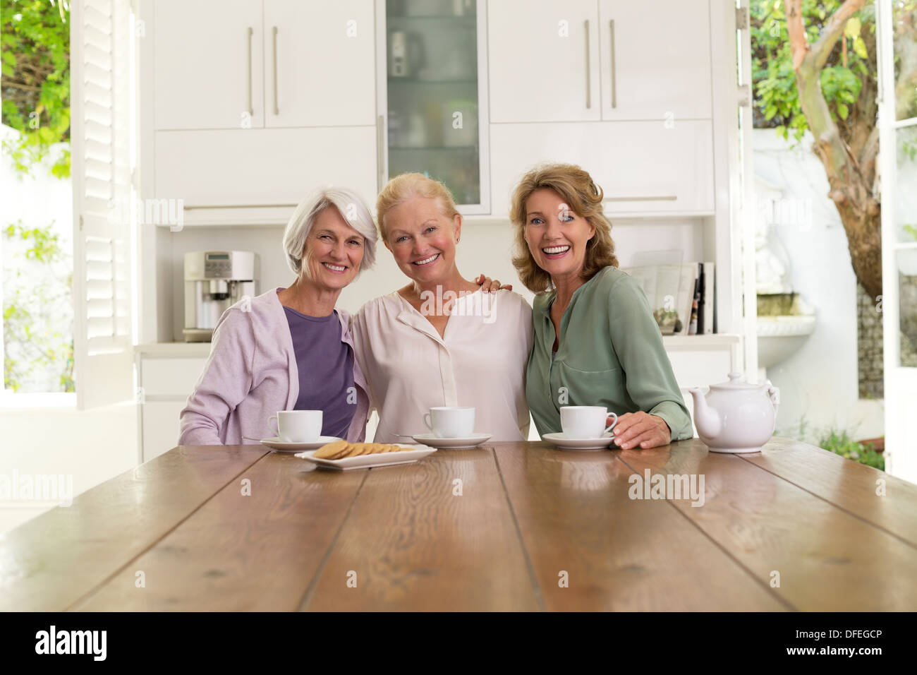 Senior women drinking coffee in kitchen Stock Photo Alamy