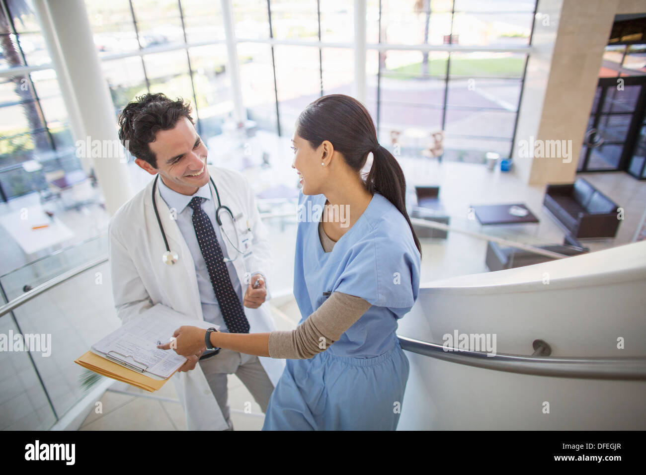 Doctor and nurse talking on staircase in hospital Stock Photo