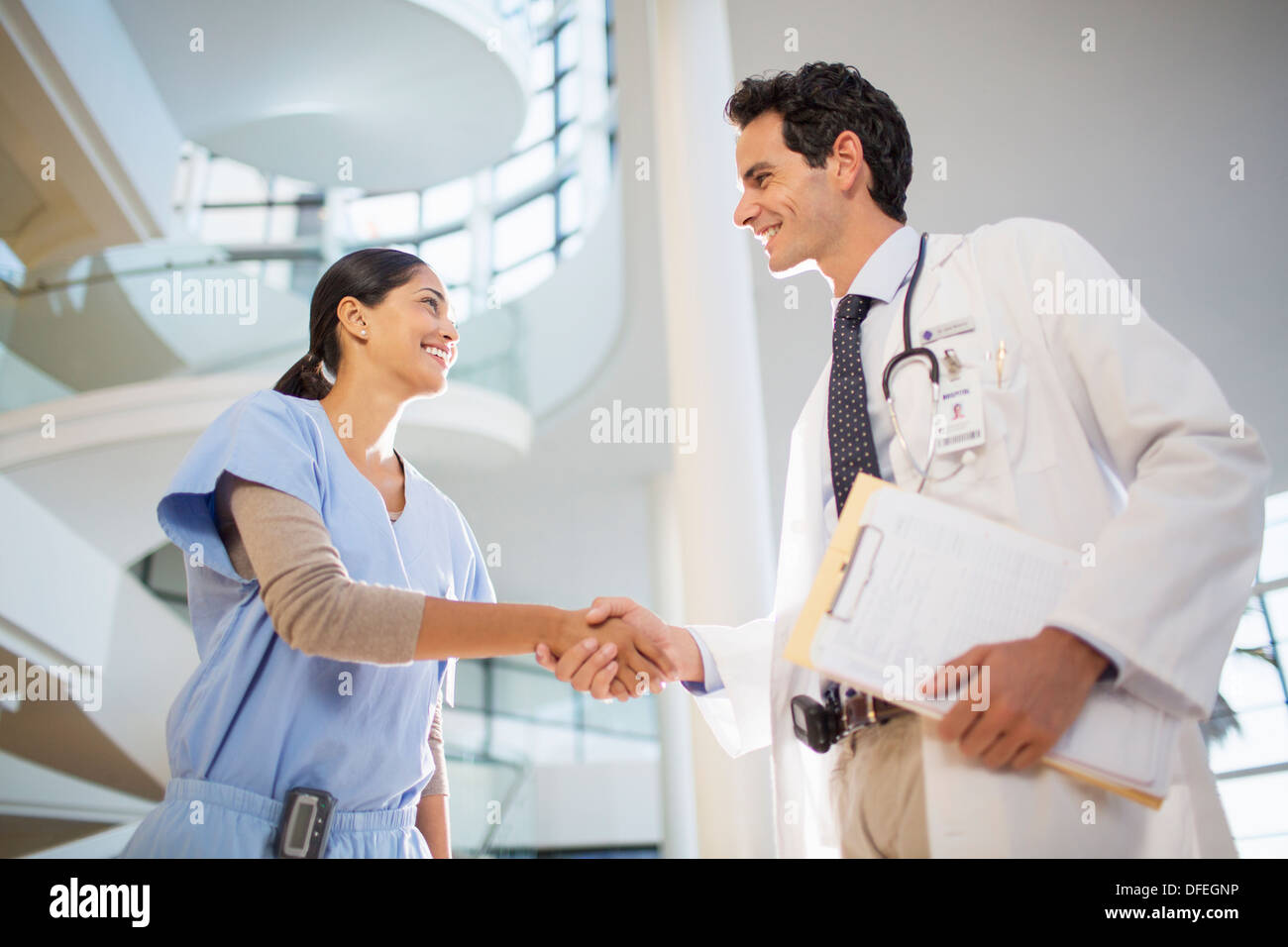 Doctor and nurse handshaking in hospital Stock Photo