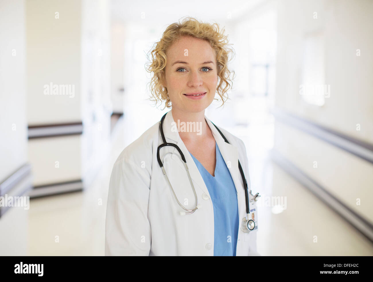 Portrait of smiling doctor in hospital corridor Stock Photo