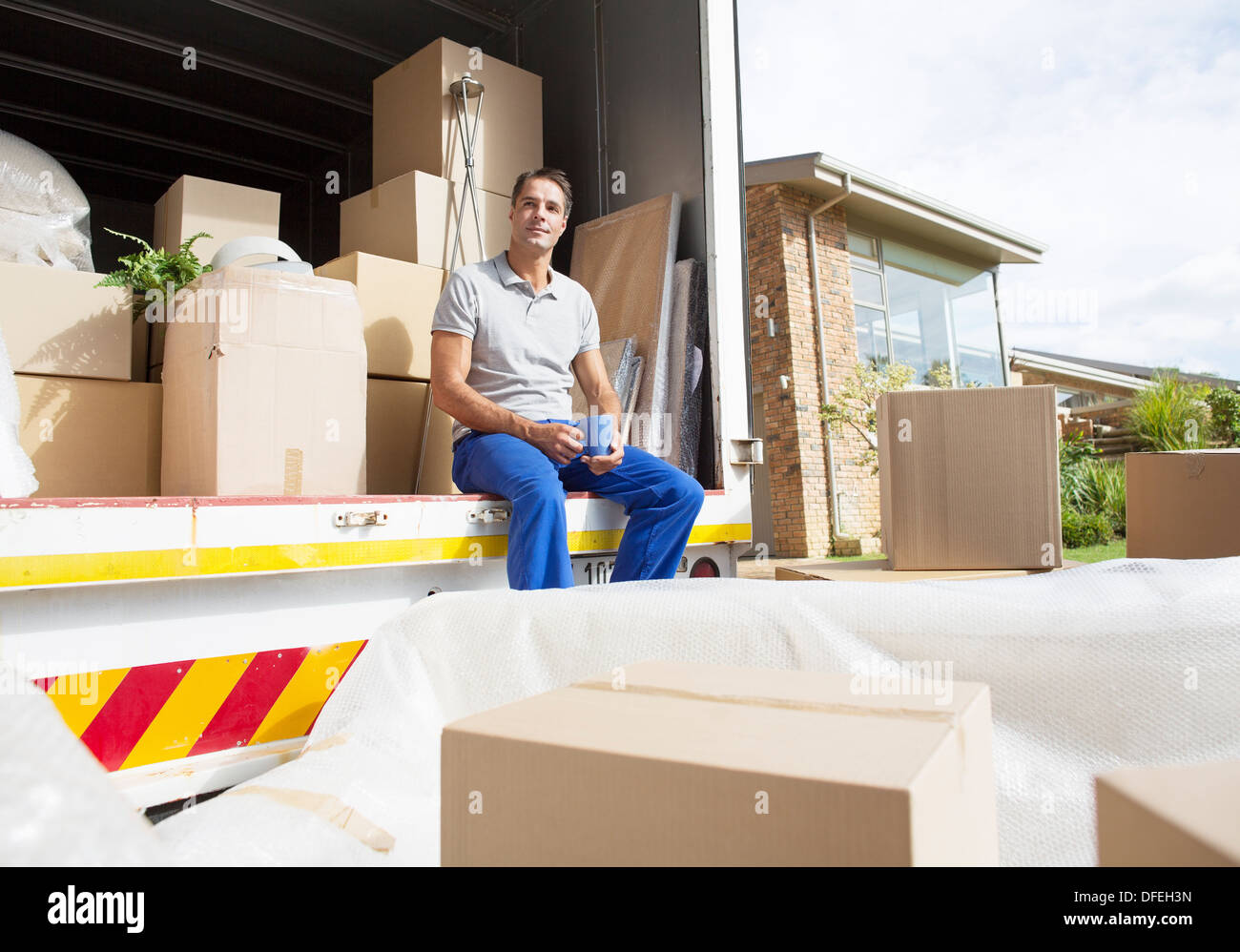 Man sitting in moving truck in driveway Stock Photo