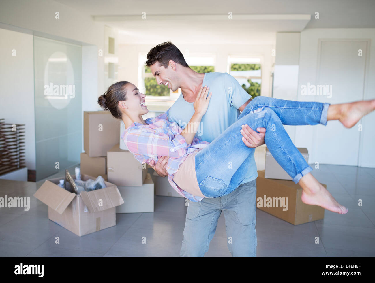 Man carrying girlfriend in new house Stock Photo