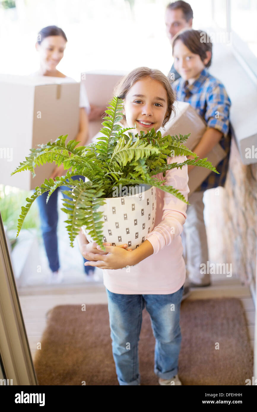 Portrait of smiling family moving belongings into house Stock Photo