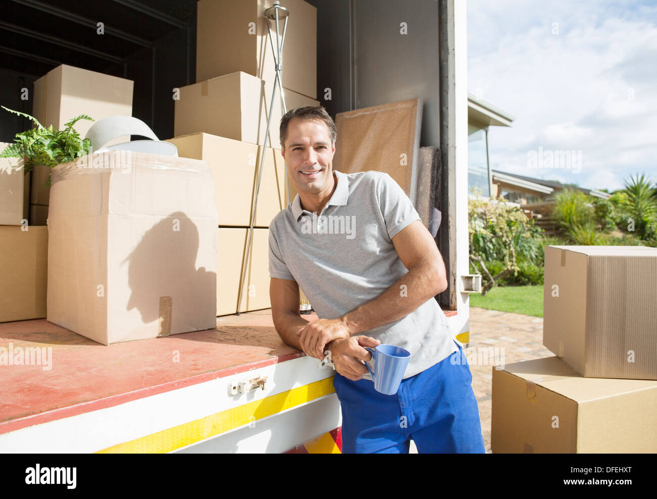 Portrait of man leaning on back of moving van Stock Photo