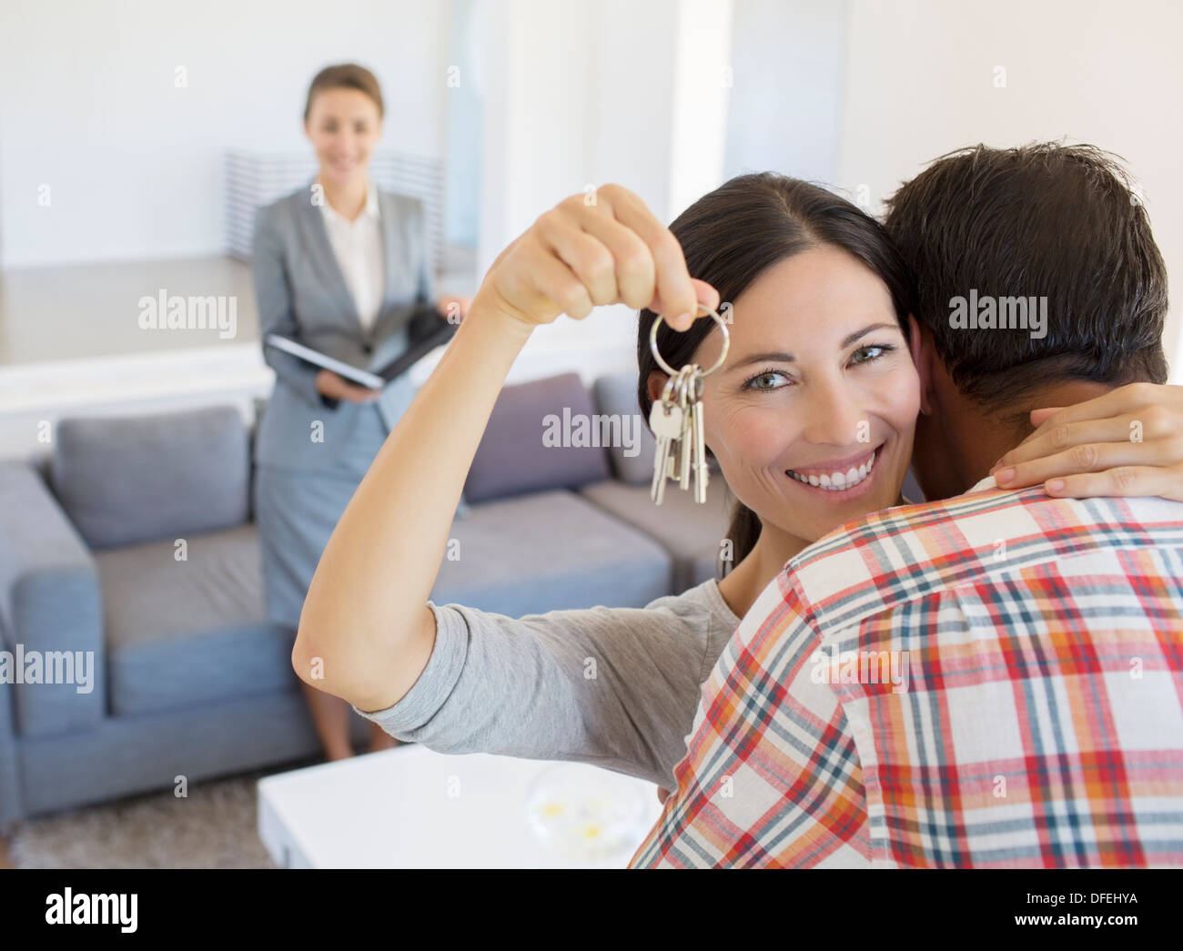 Portrait of happy couple hugging with house keys Stock Photo